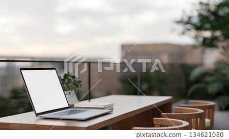 White screen laptop on wooden counter at a cafe or building's terrace with glass railing partitions. White screen laptop on wooden counter at a cafe or building's terrace with glass railing partitions. 134621080