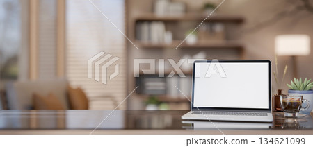 Blank screen laptop with coffee cup and diffuser on glass top wooden table in living room or bedroom Blank screen laptop with coffee cup and diffuser on glass top wooden table in living room or bedroom 134621099