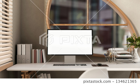 White screen computer with books and folders on wooden table under window in bedroom or living room. 134621365
