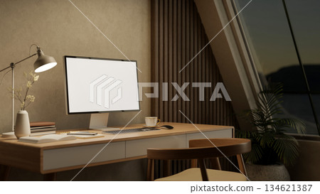 White screen computer with books aside lamp on wooden table and armchair in a bedroom or living room 134621387