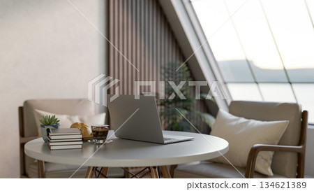 Laptop with coffee and breads aside books on white round table with armchair in living room or cafe. Laptop with coffee and breads aside books on white round table with armchair in living room or cafe. 134621389