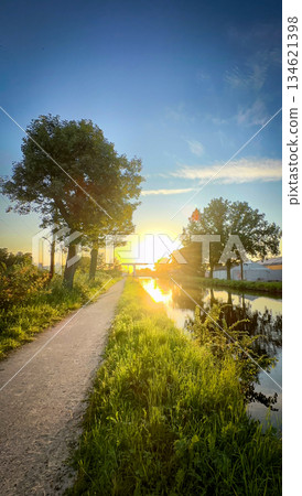 A Tranquil Pathway by the Beautiful River at Sunset, Embracing Natures Splendor A Tranquil Pathway by the Beautiful River at Sunset, Embracing Natures Splendor 134621398