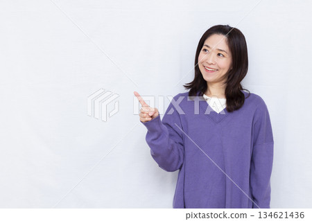 Smiling woman pointing up her index finger 134621436