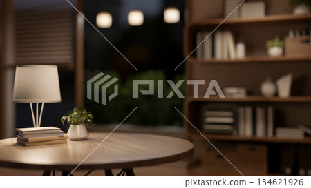 Books under lamp on round wooden table with blurred background of a living room or bedroom at night. Books under lamp on round wooden table with blurred background of a living room or bedroom at night. 134621926