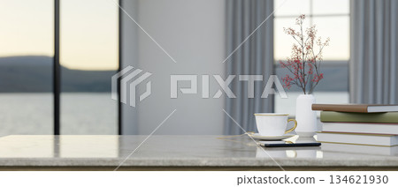 Coffee cup aside books and flower vase on marble counter in living room or cafe with scenery outside 134621930