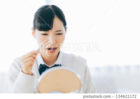 高中女生正在貼祛痘貼 134622172