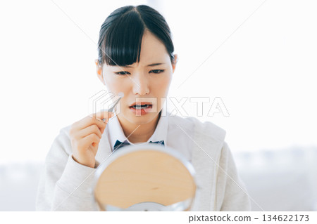 高中女生正在貼祛痘貼 134622173