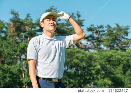 Male golfer looking up at the sky on the golf course Male golfer looking up at the sky on the golf course 134622237