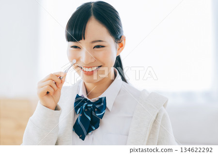 一位笑容燦爛的高中女生正在貼祛痘貼。 134622292