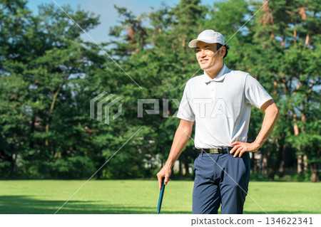 Male golfer wearing golf wear among fresh greenery (golf course, academy, membership) Male golfer wearing golf wear among fresh greenery (golf course, academy, membership) 134622341