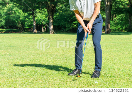 Male golfer playing golf (putter) on a golf course Male golfer playing golf (putter) on a golf course 134622361