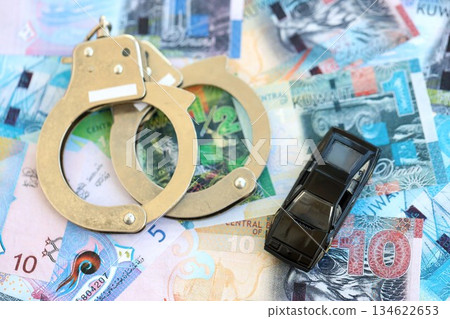 Kuwaiti dinar currency money bills and toy car with handcuffs close up. The concept of car accident 134622653