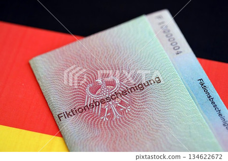 German temporary Permanent resident card specimen lies on Germany flag close up. Fiktionsbescheinigung 134622672
