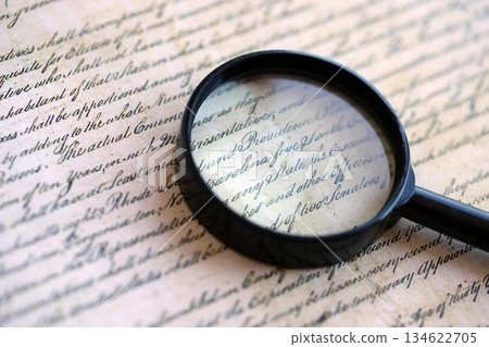 Magnifying glass and United States Constitution. American USA Constitution paper page and loupe close up 134622705