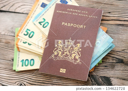 Netherlands passport lies with euro money banknotes on wooden background close up. Cash and payments in Europe concept 134622728