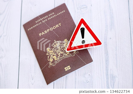 Netherlands passport with exclamation sign on white wooden background close up. Problems with citizenship in Europe concept 134622734
