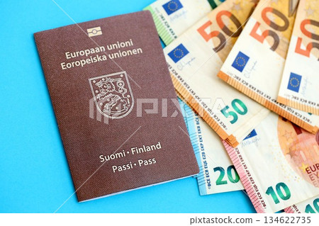 Finland passport lies with euro money banknotes on blue background close up. Salary and pension in Europe concept 134622735
