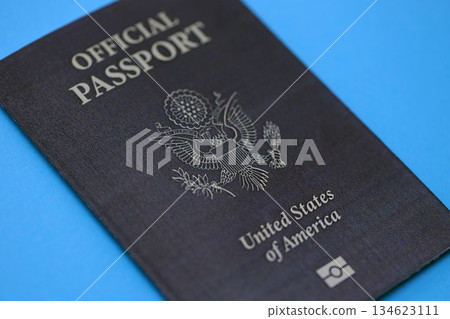 United States official passport book on light blue paper background close up. Travel document on blue surface 134623111