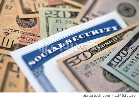 Social security number card on many US dollar money bills close up Social security number card on many US dollar money bills close up 134623156