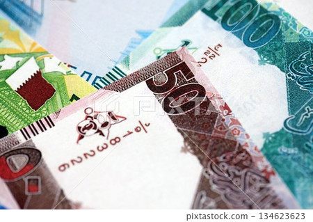 Qatari riyal money bills banknotes lies in big pile on table close up. Concept of finances and business in Qatar Qatari riyal money bills banknotes lies in big pile on table close up. Concept of finances and business in Qatar 134623623