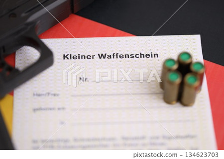German light firearms license and handgun with bullets on Germany flag close up. Gun permit for light weapon carrying in Deutschland German light firearms license and handgun with bullets on Germany flag close up. Gun permit for light weapon carrying in Deutschland 134623703