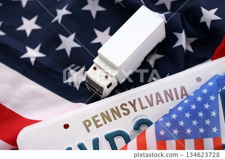 Toy truck and USA state of Pennsylvania license plate on US flag. Concept of driving in Pennsylvania. Reaching a driving permit Toy truck and USA state of Pennsylvania license plate on US flag. Concept of driving in Pennsylvania. Reaching a driving permit 134623728