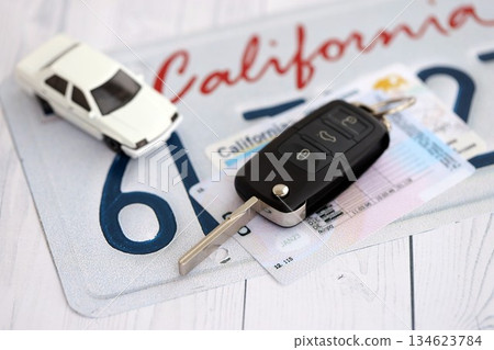 Remote control car keys on California license plate with driver license. Concept of driving in California. Reaching a driving permit 134623784