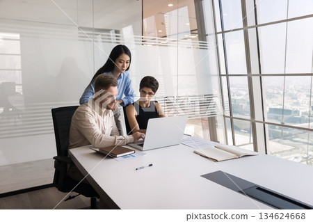Three young multiracial colleagues working on joint task using laptop Three young multiracial colleagues working on joint task using laptop 134624668