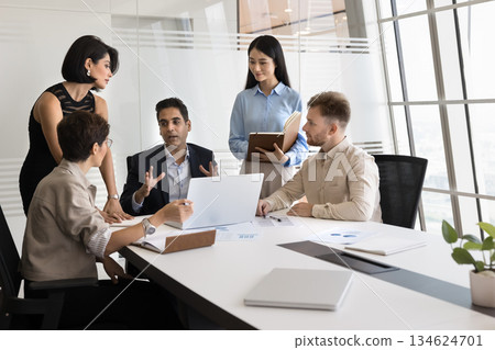 Employees listening boss during group meeting in modern conference room 134624701