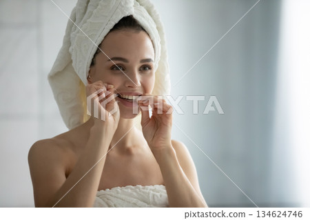 Headshot portrait beautiful young woman cleaning teeth with dental floss 134624746