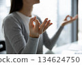 Cropped closeup young female student worker meditating at work desk 134624750