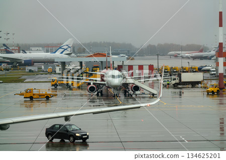 An airplane at the airport with boarding ramps. 134625201