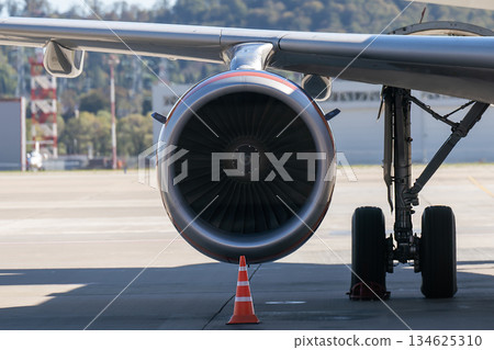 A jet engine pod under the wing of a passenger airplane. A jet engine pod under the wing of a passenger airplane. 134625310
