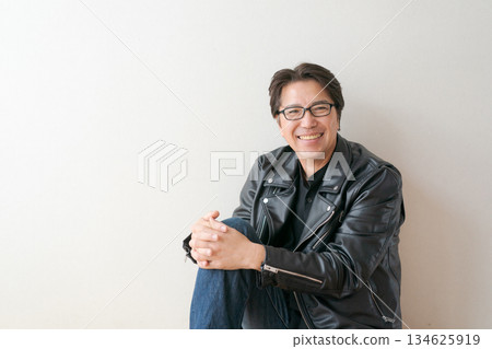 一位五十多歲、戴著眼鏡、穿著皮夾克的男子 134625919