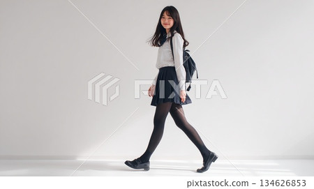Studio shot of a walking Japanese high school girl | Clean, monotone uniform-style fashion 134626853