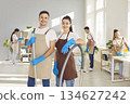 Male, female cleaners posing, group working, professional janitor service busy completing cleaning  134627242
