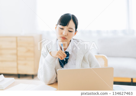 一位表情嚴肅的高中生正在上網課 134627463