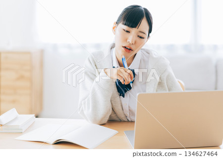 一位表情嚴肅的高中生正在上網課 134627464