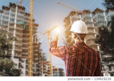 Engineer Architect Controlling Construction Process of Modern Building Site Engineer Architect Controlling Construction Process of Modern Building Site 134628226