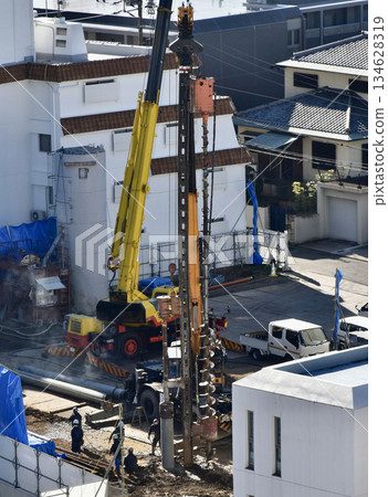 一台大型起重機正在建築工地打入混凝土樁。 一台大型起重機正在建築工地打入混凝土樁。 134628319