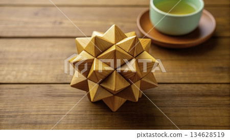 Wooden puzzle ball and tea cup set on a wooden table during afternoon 134628519