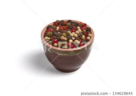 Mix of multi-colored peppercorns in a ceramic bowl isolated on white background. 134629645