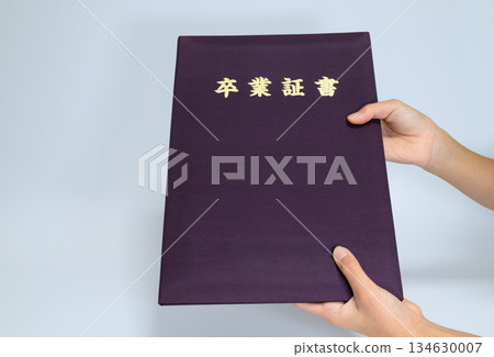 兒童的手拿著畢業證書封面，留有空白區域。 134630007