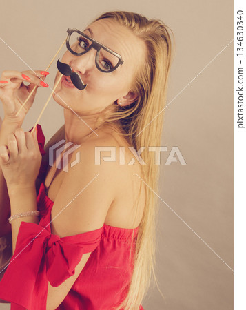 Woman with party decoration mask sticks 134630340