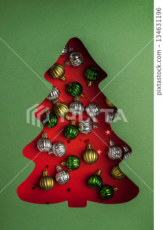 Christmas Tree Cutout Filled with Metallic Ornaments on Green Background Christmas Tree Cutout Filled with Metallic Ornaments on Green Background 134631196