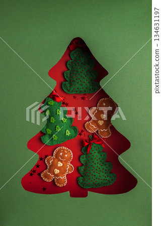 Handmade Felt Christmas Decorations in Tree Cutout on Green Background 134631197