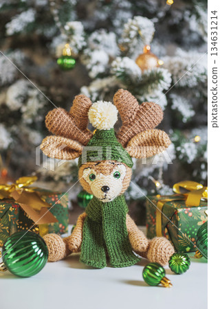 Crocheted Reindeer with Gifts and Christmas Tree in Festive Interior 134631214