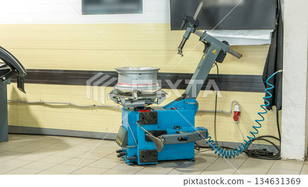 Professional car mechanic replace tire on wheel in auto repair service timelapse. 134631369