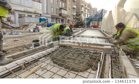Pouring ready-mixed concrete after placing steel reinforcement to make the road by concrete mixer timelapse hyperlapse. Pouring ready-mixed concrete after placing steel reinforcement to make the road by concrete mixer timelapse hyperlapse. 134631379