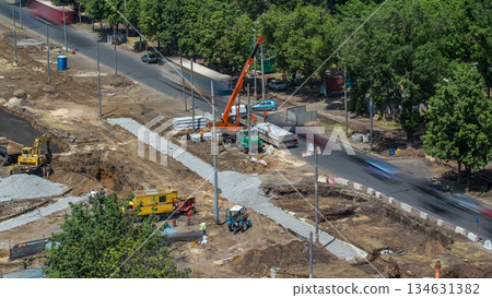 Unloading concrete plates from truck by crane at road construction site aerial timelapse. 134631382